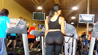 Voyeur finds a sexy brunette with a fabulous ass in the gym